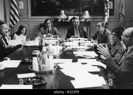 Les membres de faculté et de l'administration à l'Université Johns Hopkins et Goucher College se rassemblent pour une réunion à une longue table de conférence avec des papiers, des tasses à café, et des cendriers éparpillés sur, Baltimore, Maryland, 1975. Banque D'Images