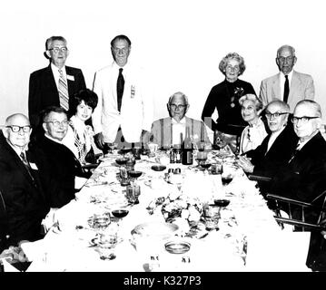 Portrait de groupe de l'Université Johns Hopkins, anciens et leurs conjoints et parents réunis autour d'une table pour l'Université « Vieille Garde' le dîner, à Baltimore, Maryland, 1965. Banque D'Images
