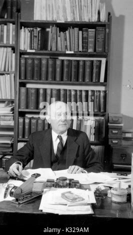 Portrait de Candide Manager de la Johns Hopkins Press Christian William Dittus assis à son bureau entouré par des journaux et des livres, 1940. Banque D'Images