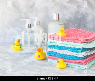 Pile de serviettes avec les canards en caoutchouc jaune et moyens pour la salle de bains en marbre blanc, sur fond de l'espace pour texte, selective focus Banque D'Images