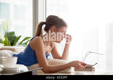 Massage femme yeux fatigués après une trop longue lecture Banque D'Images