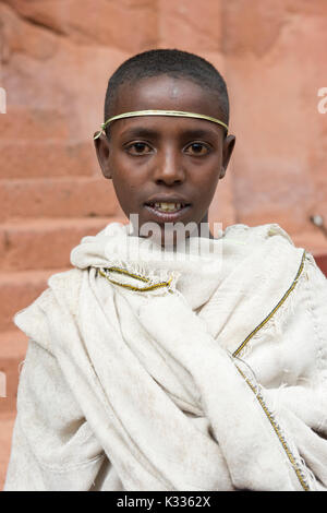 Pèlerin de jeunes hommes vêtus de robes blanches traditionnel, avec une palme autour de son front, près de l'église, Bet Amanuel pendant les prières sur l'Ethiopie Pâques Samedi, Lalibela, Éthiopie Banque D'Images