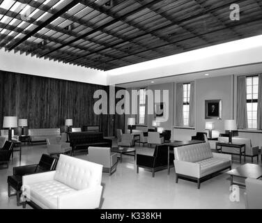 L'intérieur de la chambre de Garrett à la Milton S Eisenhower Library à l'Université Johns Hopkins, un espace salon rempli de canapés et des chaises disposées en groupes autour d'une table basse et lampes de table, avec des portraits de chaire universitaire les membres et donateurs sur le mur entre les fenêtres, et un plafond à poutres avec fuite de lumière à travers, Baltimore, Maryland, 1965. Banque D'Images