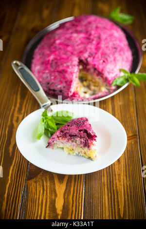 Salade de pâte en couches avec le hareng et de betterave sur une table en bois Banque D'Images