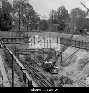 Au cours des premières étapes de la construction de la Milton S Eisenhower Library à l'Université Johns Hopkins, l'acier est mis dans la fondation de l'édifice, avec des arbres et des bâtiments du campus bordant le projet sol, Baltimore, Maryland, Mai, 1962. Banque D'Images