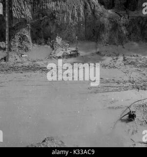 Au cours des premières étapes de la construction de la Milton S Eisenhower Library à l'Université Johns Hopkins, le bas de la fondations du bâtiment est rempli avec de l'eau boueuse après une tempête de pluie, en attente d'être nettoyés par les travailleurs, Baltimore, Maryland, 1962. Banque D'Images