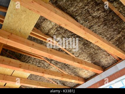 Toit et isolation thermique des combles sur les faisceaux en bois dans une nouvelle maison. Banque D'Images