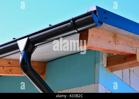 Libre d'une gouttière de toit en acier noir sur une nouvelle maison avec mur isolé. Banque D'Images