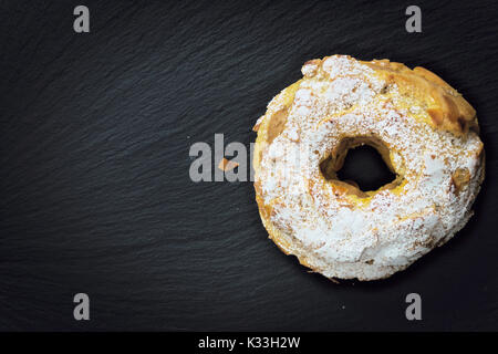 Paris Brest dessert français célèbre pâtisserie ronde doux sous la forme d'une roue sur la plaque en ardoise noire with copy space Banque D'Images