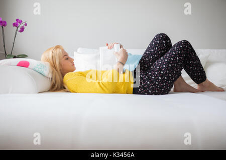 Une photo de jeune femme couché sur la table et de la lecture livre attentivement. Banque D'Images