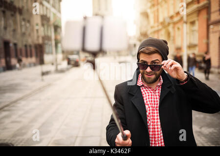 Une photo de l'homme jeune et branché en prenant lui-même une photo de son téléphone mobile. Banque D'Images