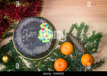 Sur une table de bois est parfaitement défini décorations et cadeaux de Noël, Nouvel an des branches de pins, Cônes, balles brillants, de gâteaux, de confettis. Banque D'Images