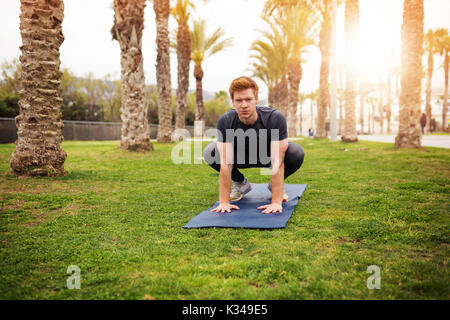 Une photo du jeune homme sportif, faire quelques exercices de yoga sur le tapis de gym. Banque D'Images