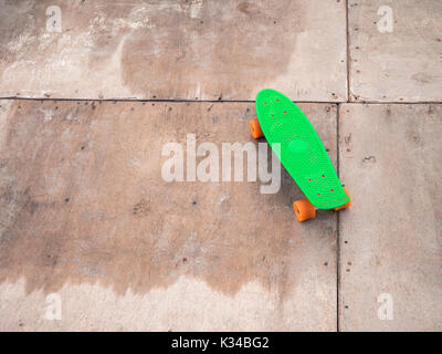 Penny vert unique sur un half-pipe en bois. Banque D'Images