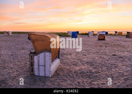 Des paniers de plage à la plage de Carolinensiel, Frise orientale alors que le soleil se couche Banque D'Images