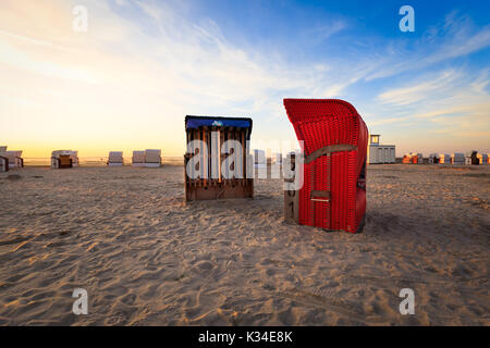 Des paniers de plage à la plage de Carolinensiel, Frise orientale alors que le soleil se couche Banque D'Images