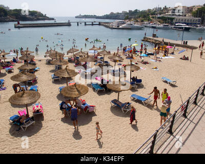 Les touristes vous détendre sous les parasols dans Porto Christo Banque D'Images