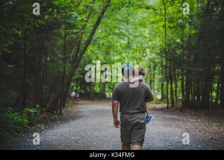 Un père porte sa fille le long d'une piste couverte. Banque D'Images