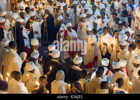 Prêtres chantant des prières aux chandelles dans la cour de l'église Medhane Alem, Pari pendant les prières sur le samedi de Pâques orthodoxe éthiopienne, Lalibela, Éthiopie Banque D'Images