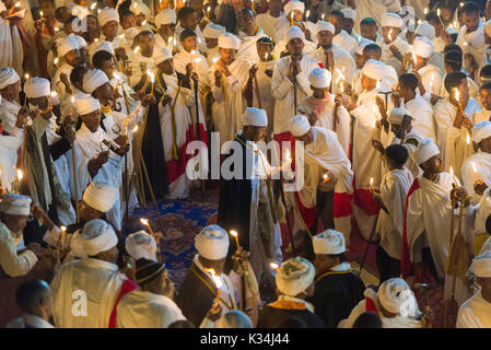 Prêtres chantant des prières aux chandelles dans la cour de l'église Medhane Alem, Pari pendant les prières sur le samedi de Pâques orthodoxe éthiopienne, Lalibela, Éthiopie Banque D'Images