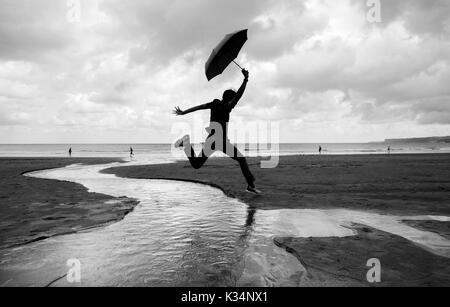 Silly marche sur une plage humide, plage Sardinero de Santander sur l'image Banque D'Images