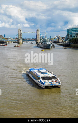 Mbna Catamaran riverboat sur la Tamise dans le bassin de Londres passant du Tower Bridge et HMS Belfast, City of London, UK Banque D'Images
