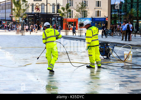 Les nettoyeurs de rue avec tuyaux à pression dans le navigateur 'Carré', retrait chewing-gums sur le nouveau centre piétonnier d'Archway, au nord de Londres, UK Banque D'Images