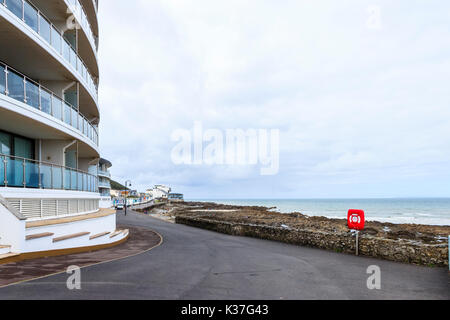 Appartements de vacances sur la promenade à Westward Ho !, Devon, Angleterre, Royaume-Uni, une bouée rouge vif sur la droite Banque D'Images