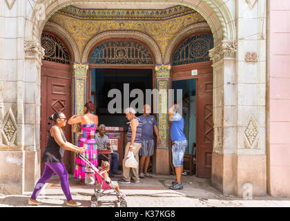 Les gens à l'entrée d'un warchmaker La Havane, relojero, bâtiment avec des décorations art déco, scène de rue à La Habana Vieja, Cuba Banque D'Images