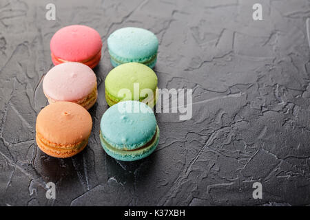 Biscuits macaron multicolores française classique noir sur fond de béton Banque D'Images