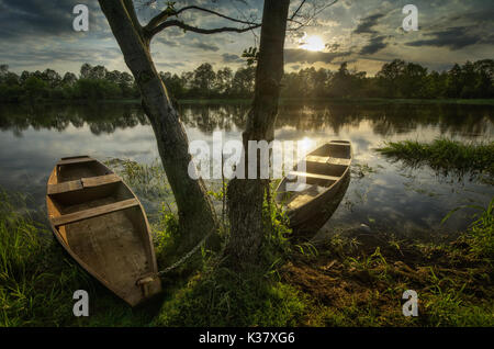 Deux bateaux en bois sur la rivière Narew au coucher du soleil, Pologne Banque D'Images