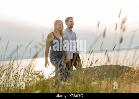 Femme enceinte à plage avec mari s'amusant Banque D'Images