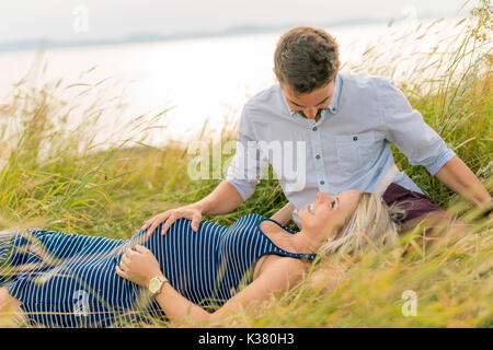 Femme enceinte à plage avec mari s'amusant Banque D'Images