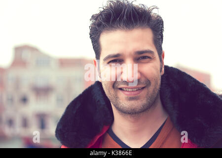 Happy young man standing outdoors sur fond d'une vieille ville Banque D'Images