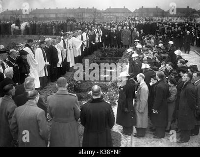 Personnes entourent la fosse commune comme les 44 victimes d'un raid de bombardement allemand sont enterrés au cimetière vert ici à Londres, la seconde guerre mondiale, le 27 janvier 1943. Trente-huit enfants et six enseignants ont été tués lorsque B-5573 Road School à Catford, sud de Londres a été directement frappé lorsqu'un Fokker-Wolf FW 190A-4 a largué une bombe 914lb à 12h30 le mercredi, 20 janvier 1943. Banque D'Images