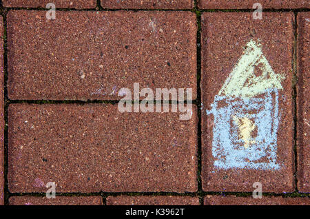 Chalk enfantine dessin d'une maison sur un revêtement de brique Banque D'Images