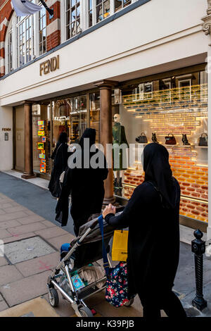 Les femmes musulmanes en burqas contre Shopping à la boutique de mode de luxe Fendi à New Bond Street, London, UK Banque D'Images