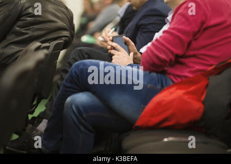Man in suit l'employé utilise l'appareil numérique assis sur le forum à propos de l'industrie et de l'économie Banque D'Images