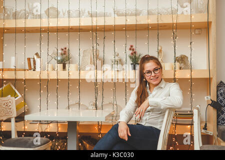 Jeune femme d'affaires est assis à la table en propre café. Banque D'Images