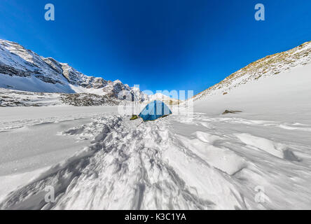 Blue tente dans les sommets enneigés des montagnes. Panorama grand angle. Banque D'Images