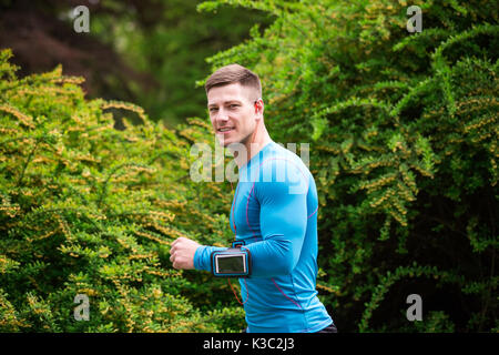 Une photo de jeune, bien bâti man jogging au parc. Banque D'Images