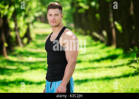 Une photo de jeune, bien bâti homme posant pour la photo au parc. Banque D'Images