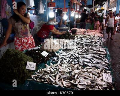 MARIKINA CITY, PHILIPPINES - le 28 août 2017 : Un vendeur vend du poisson frais et autres seafolds dans un magasin dans un marché public. Banque D'Images