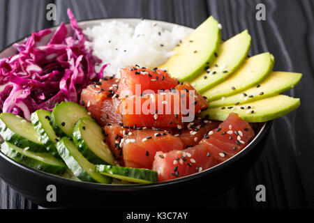 Thon ahi poke biologiques crus avec du riz et légumes bol close-up sur la table horizontale. Banque D'Images