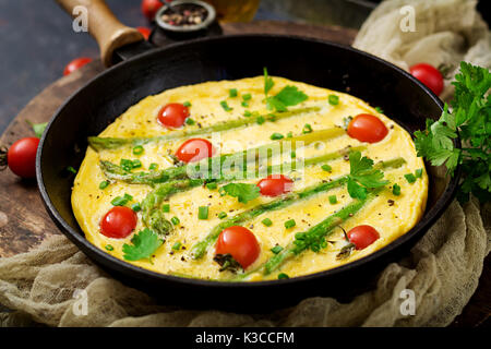 Omelette (omelette) avec les tomates, les asperges et les oignons verts Banque D'Images