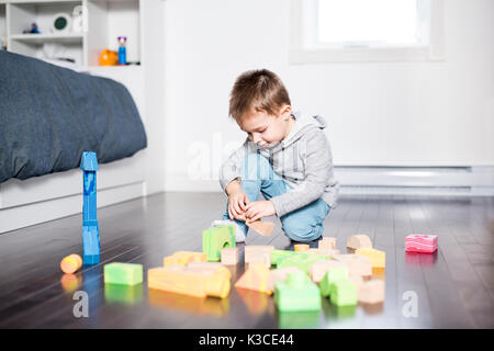 Mignon enfant jouant avec la couleur à l'intérieur de jouets Banque D'Images