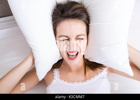 Jeune femme endormie dans la chambre à la maison portant en blanc Banque D'Images