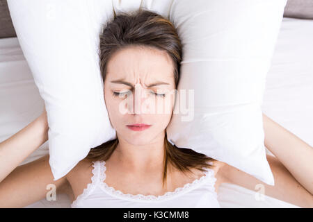 Jeune femme endormie dans la chambre à la maison portant en blanc Banque D'Images