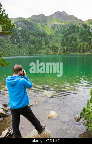 L'homme prend une photo de paysage paysage pittoresque en Autriche. Beau lac de montagne isolé, turquoise clair comme de l'eau, entouré par la forêt. Banque D'Images
