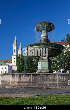 Puits en face de l'université Ludwig Maximilian avec Ludwigskirche (Église Saint-louis) dans Ludwigstrasse, Munich, Maxvorstadt, Haute-Bavière, Bavière, Allemagne, Banque D'Images